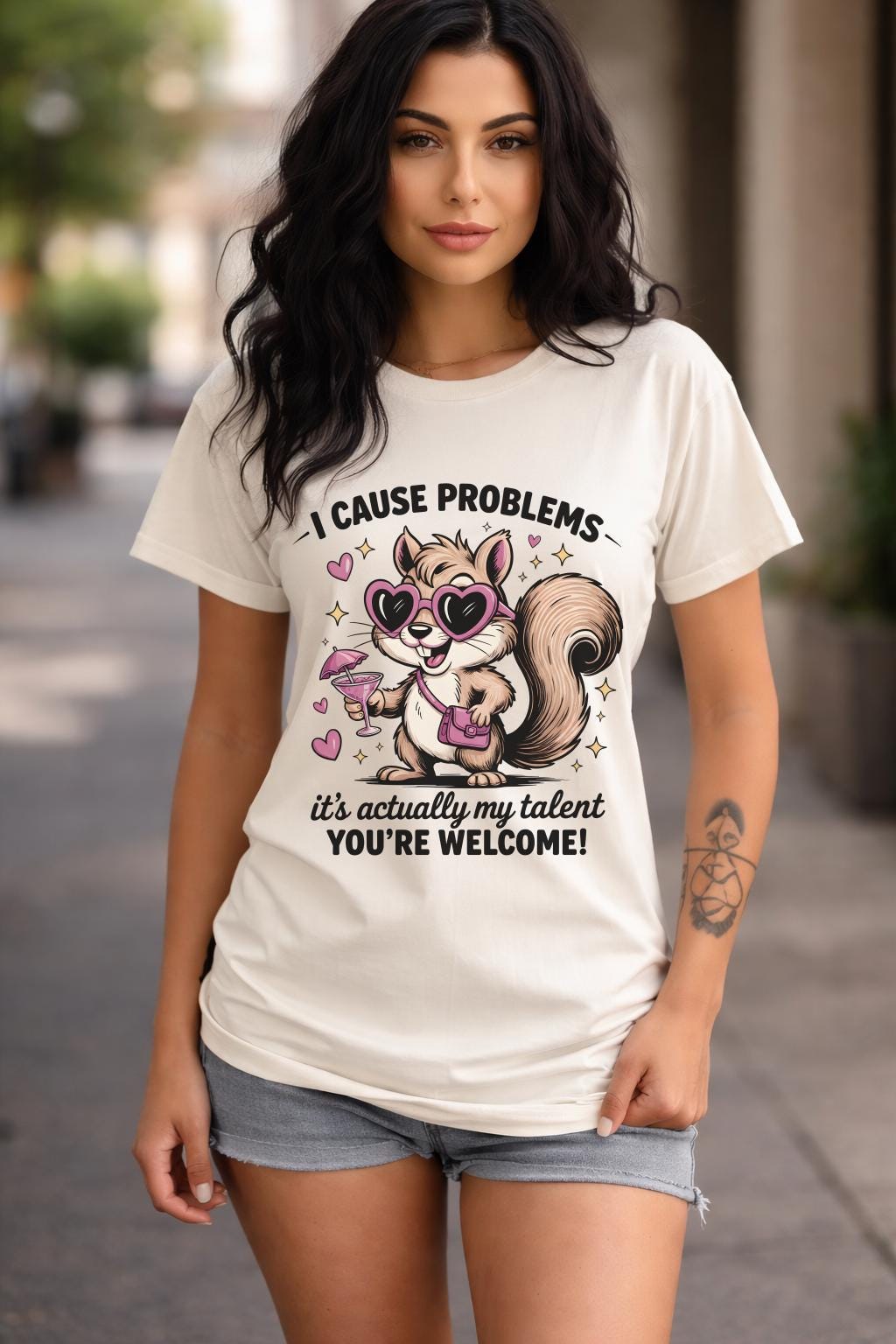 Funny squirrel graphic t-shirt with playful quote “I cause problems it’s actually my talent,” featuring cartoon squirrel with sunglasses and cocktail, worn as a casual summer outfit.