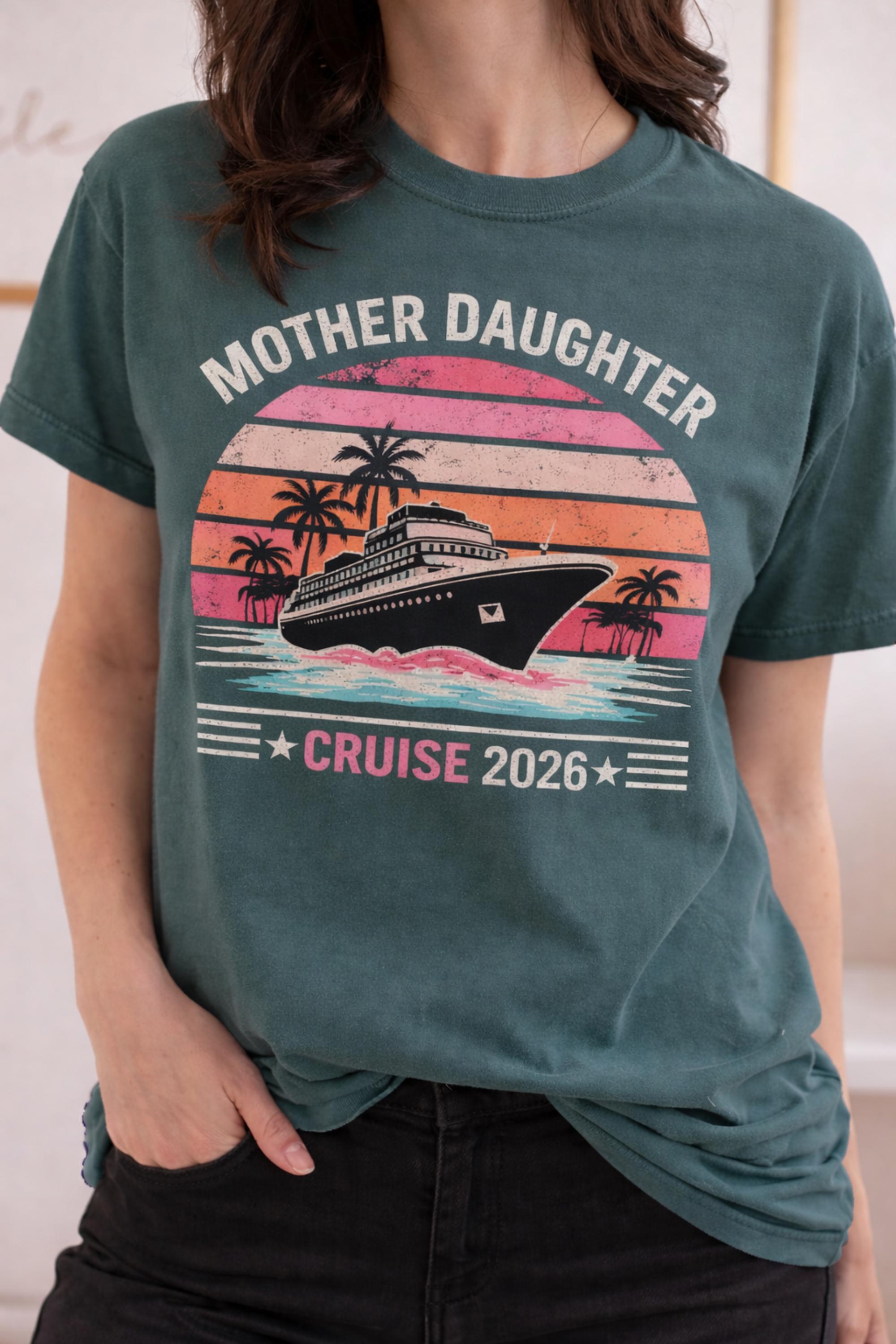 Woman wearing a Blue Spruce Comfort Colors t-shirt featuring a retro Mother Daughter Cruise 2026 design with a vintage sunset, palm trees, and cruise ship graphic