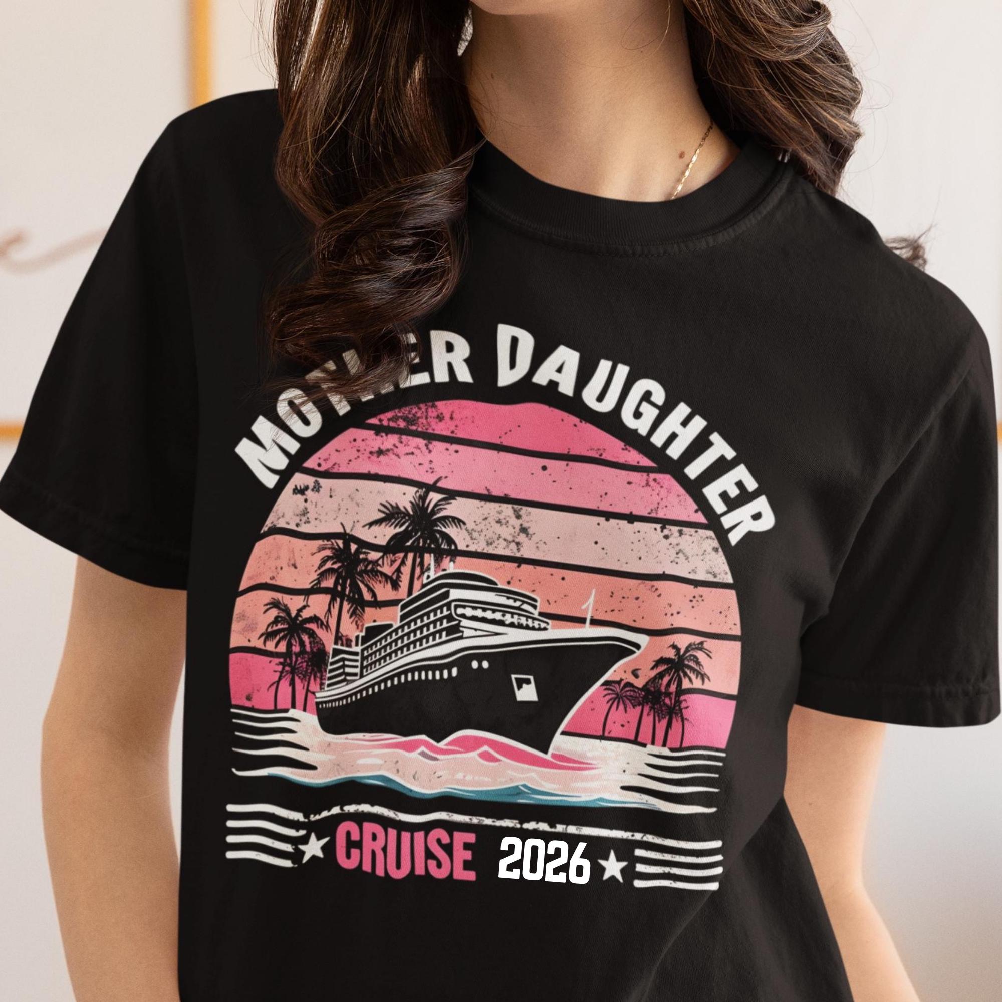 Woman wearing a Black Comfort Colors t-shirt featuring a retro Mother Daughter Cruise 2026 design with a vintage sunset, palm trees, and cruise ship graphic