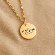 Custom engraved round pendant necklace with script name, date, and celestial star moon engraving