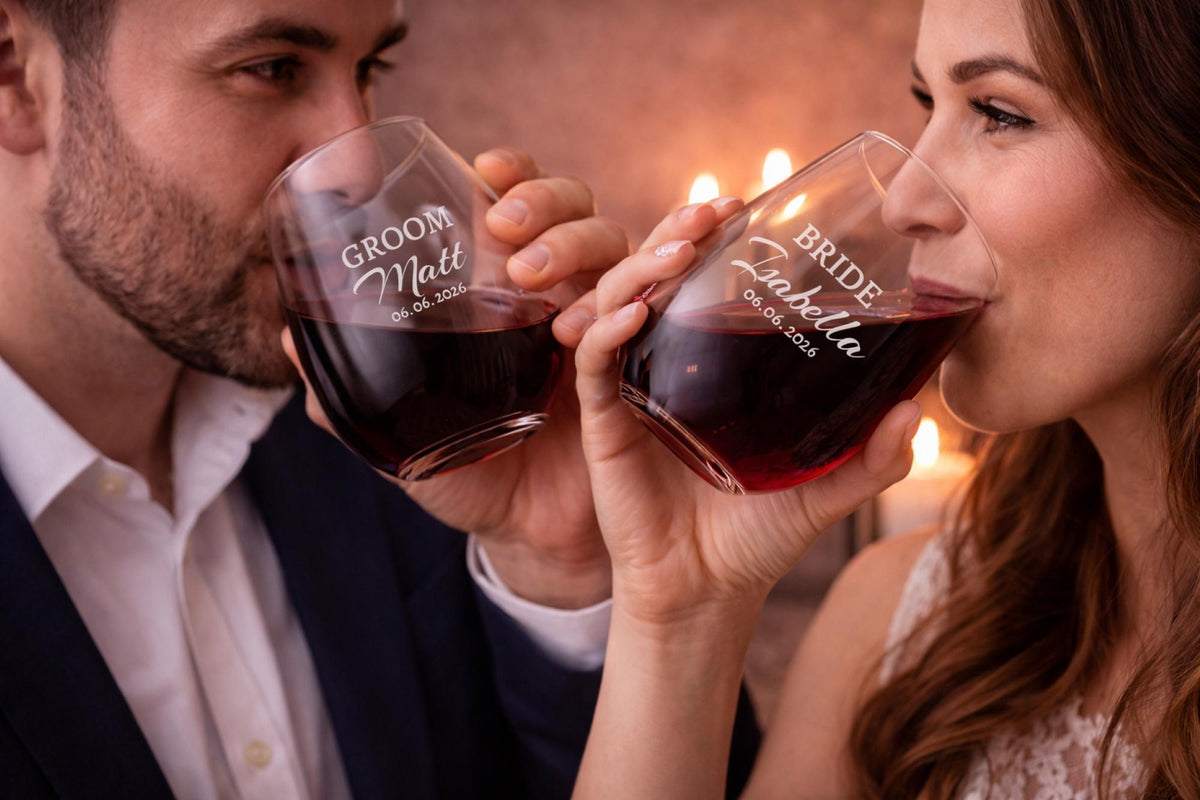 Romantic glassware with personalized lettering placed on a wooden surface with soft lighting