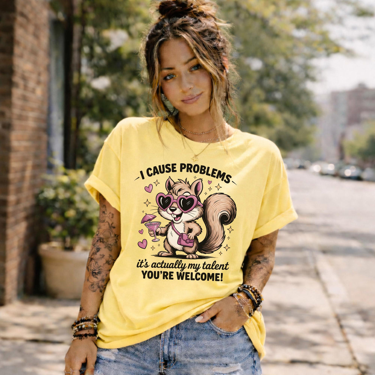 Funny squirrel graphic t-shirt with playful quote “I cause problems it’s actually my talent,” featuring cartoon squirrel with sunglasses and cocktail, worn as a casual summer outfit.