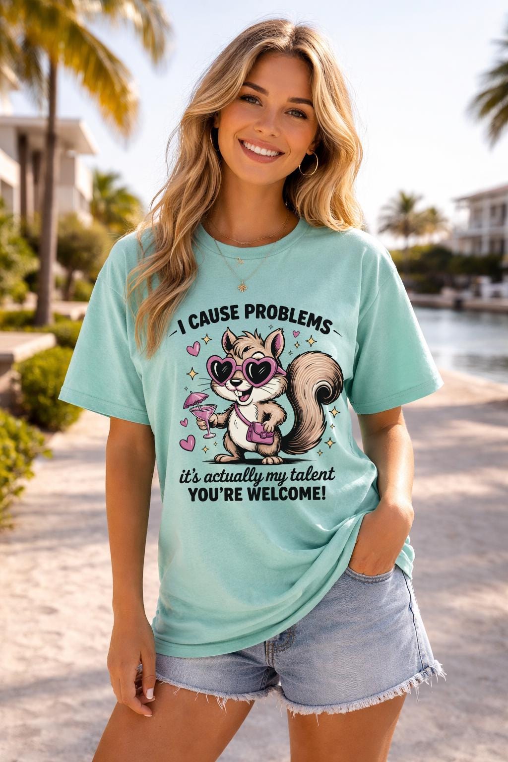 Funny squirrel graphic t-shirt with playful quote “I cause problems it’s actually my talent,” featuring cartoon squirrel with sunglasses and cocktail, worn as a casual summer outfit.