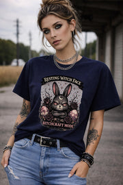 Woman wearing black gothic bunny graphic t-shirt with text Resting Witch Face Bitchcraft Mode styled with denim jeans and layered jewelry