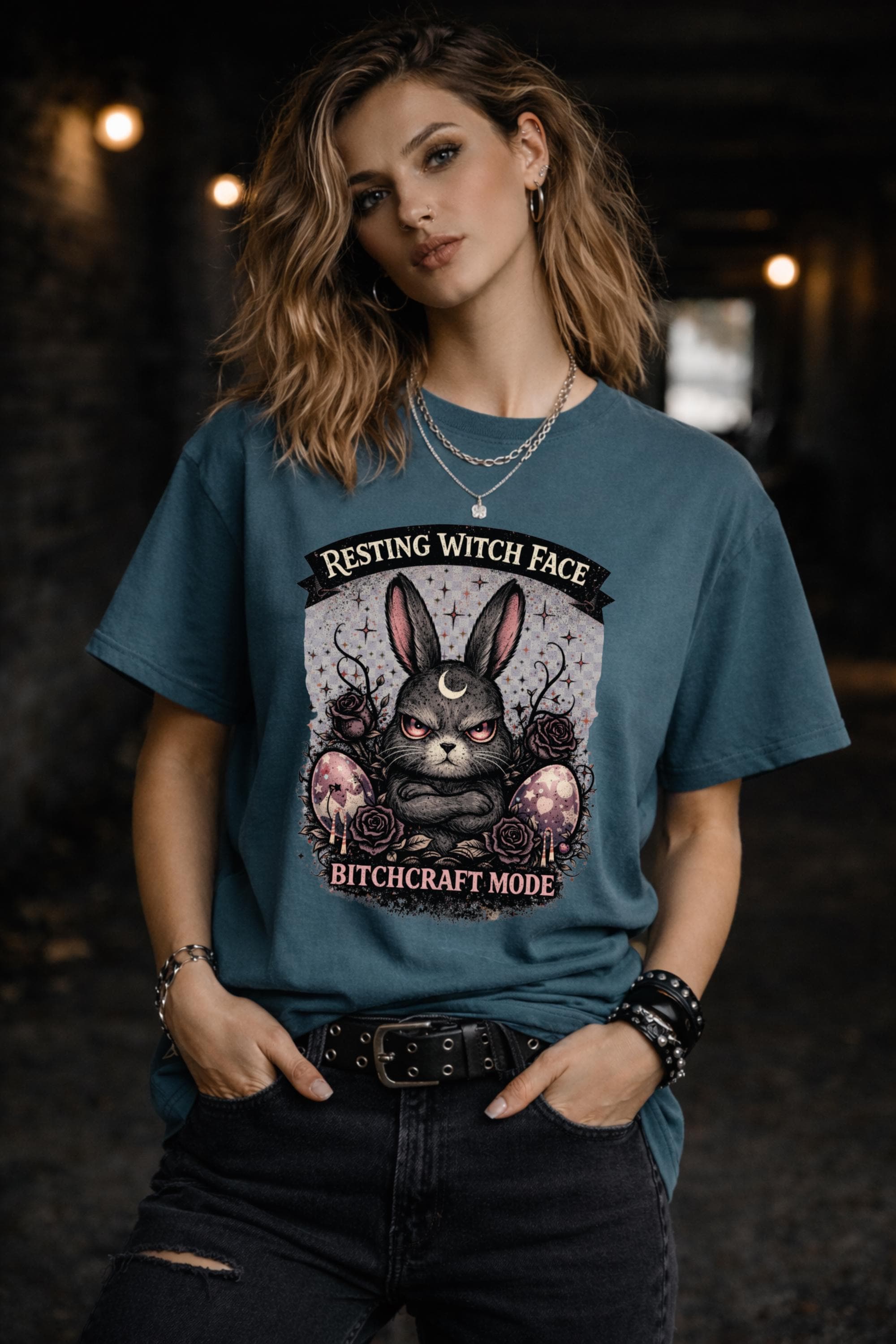 Woman wearing black gothic bunny graphic t-shirt with text Resting Witch Face Bitchcraft Mode styled with denim jeans and layered jewelry