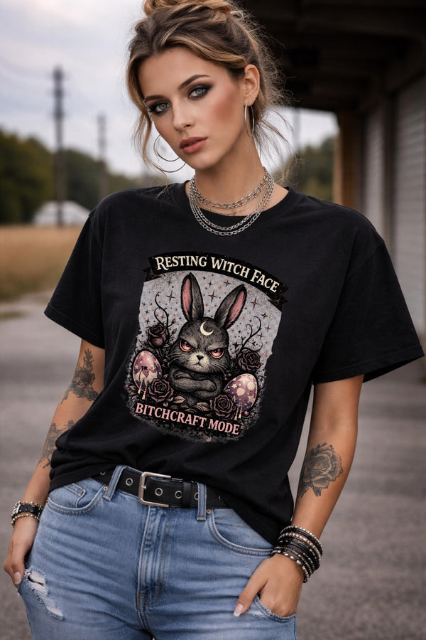 Woman wearing black gothic bunny graphic t-shirt with text Resting Witch Face Bitchcraft Mode styled with denim jeans and layered jewelry