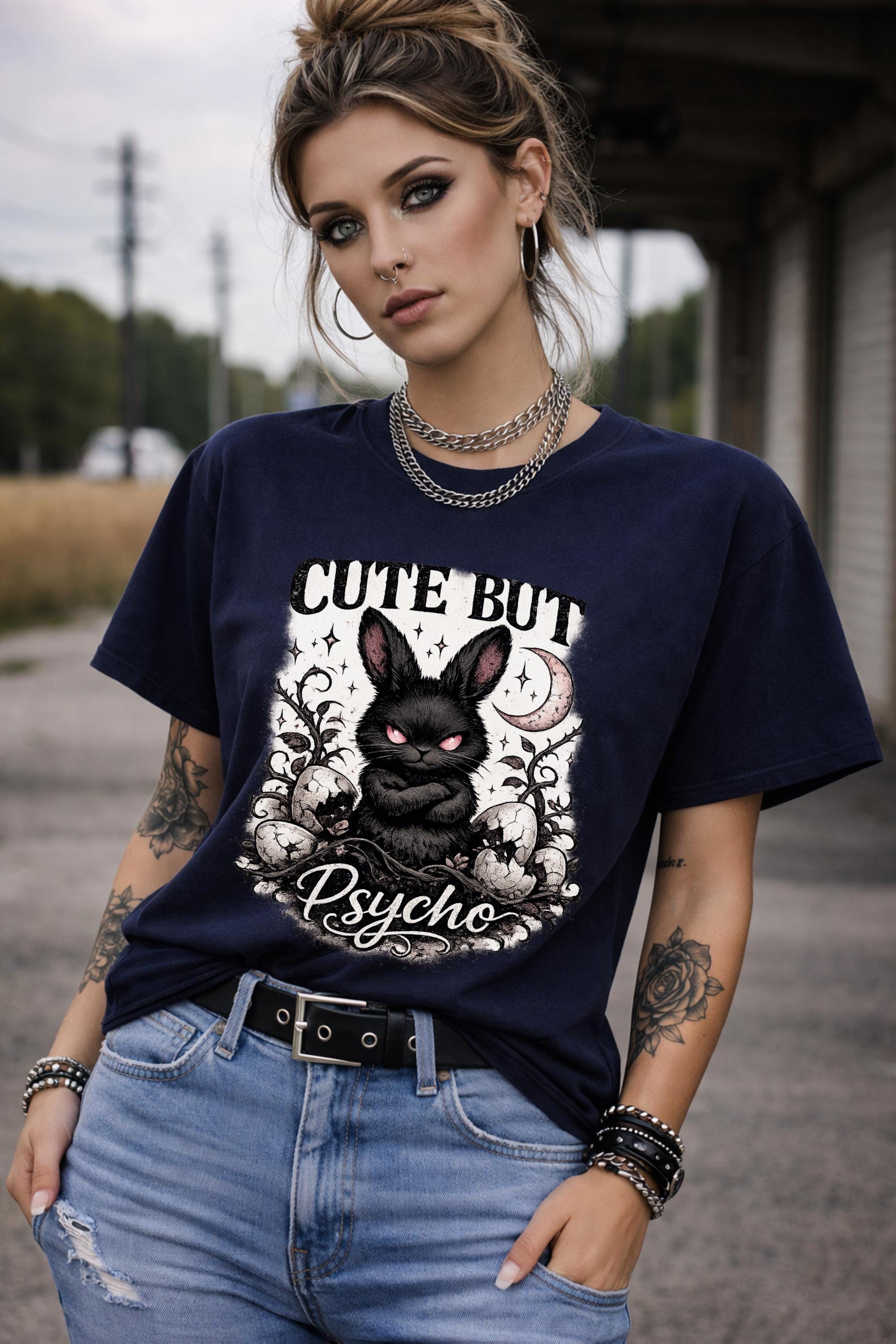 Graphic t-shirt featuring gothic bunny with glowing eyes and “Cute But Psycho” text, worn by model on beach with casual summer outfit