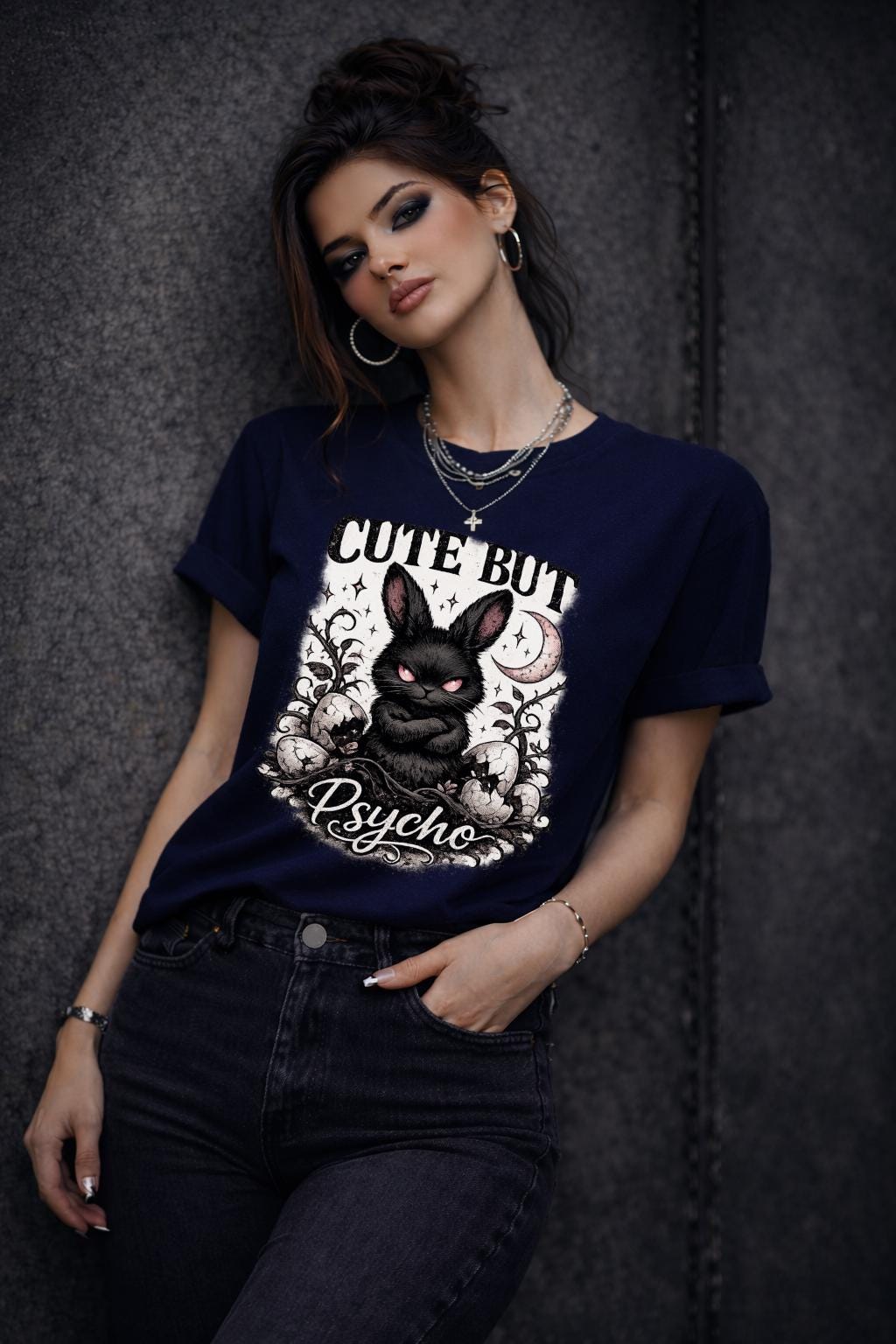 Graphic t-shirt featuring gothic bunny with glowing eyes and “Cute But Psycho” text, worn by model on beach with casual summer outfit