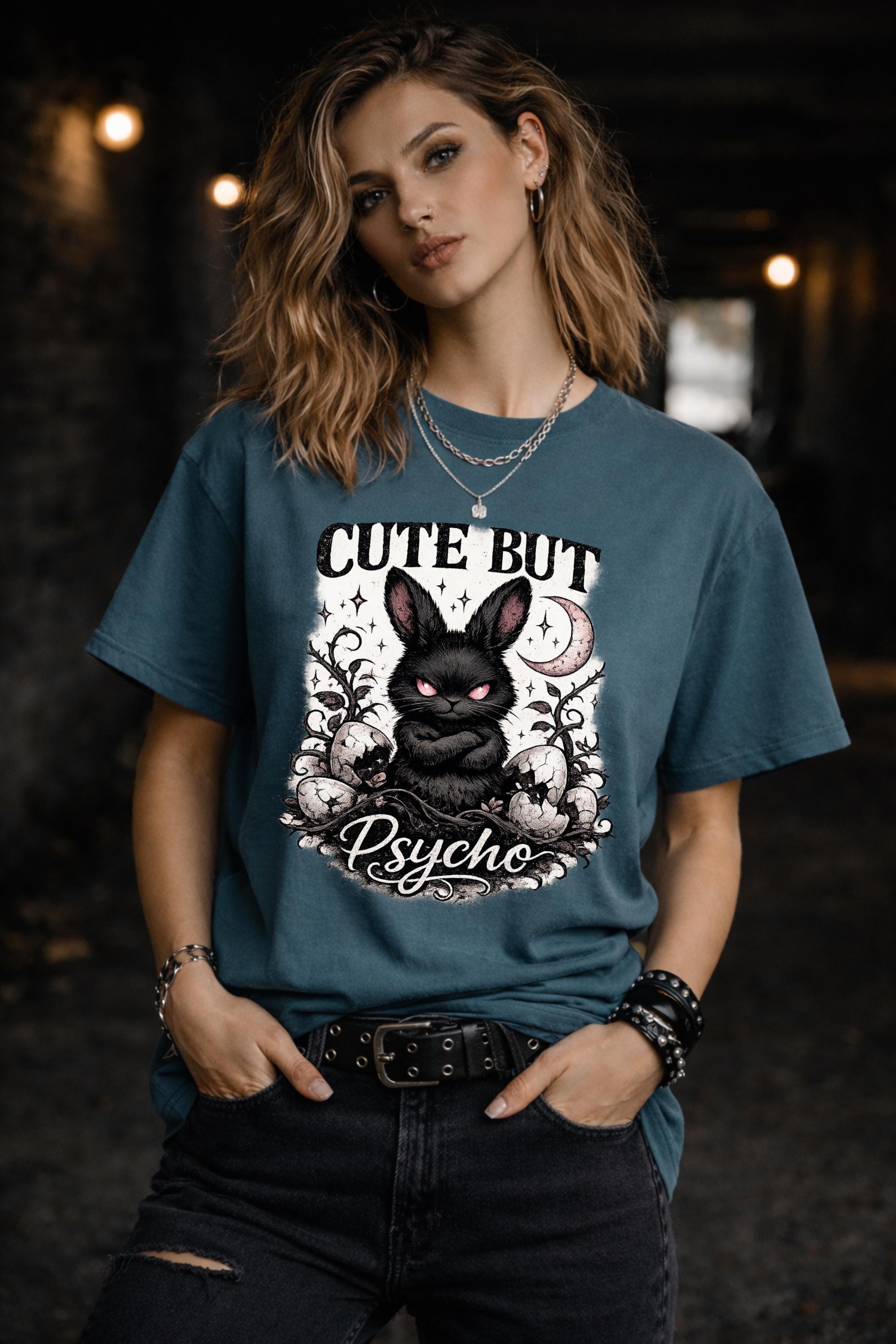 Graphic t-shirt featuring gothic bunny with glowing eyes and “Cute But Psycho” text, worn by model on beach with casual summer outfit