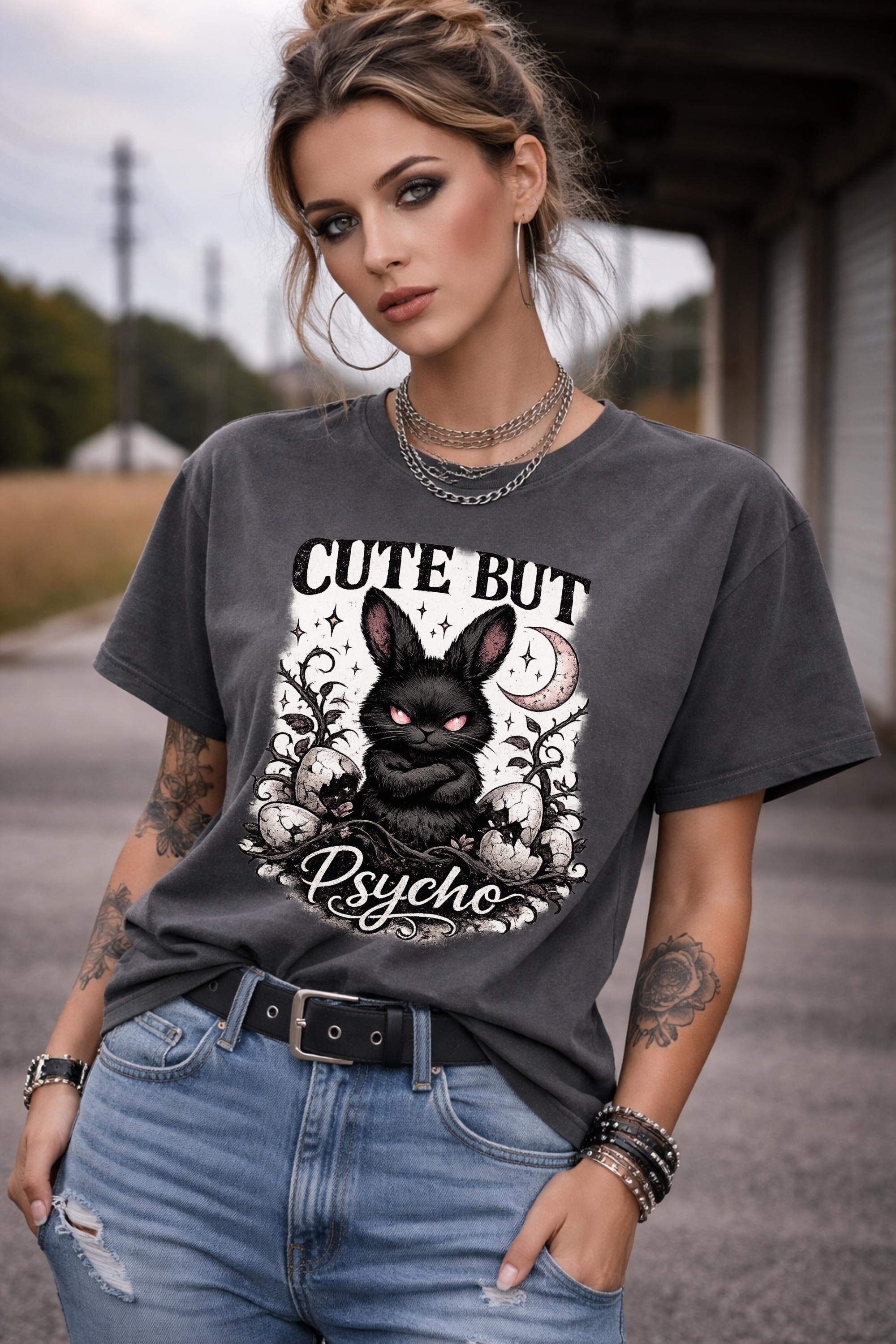 Graphic t-shirt featuring gothic bunny with glowing eyes and “Cute But Psycho” text, worn by model on beach with casual summer outfit
