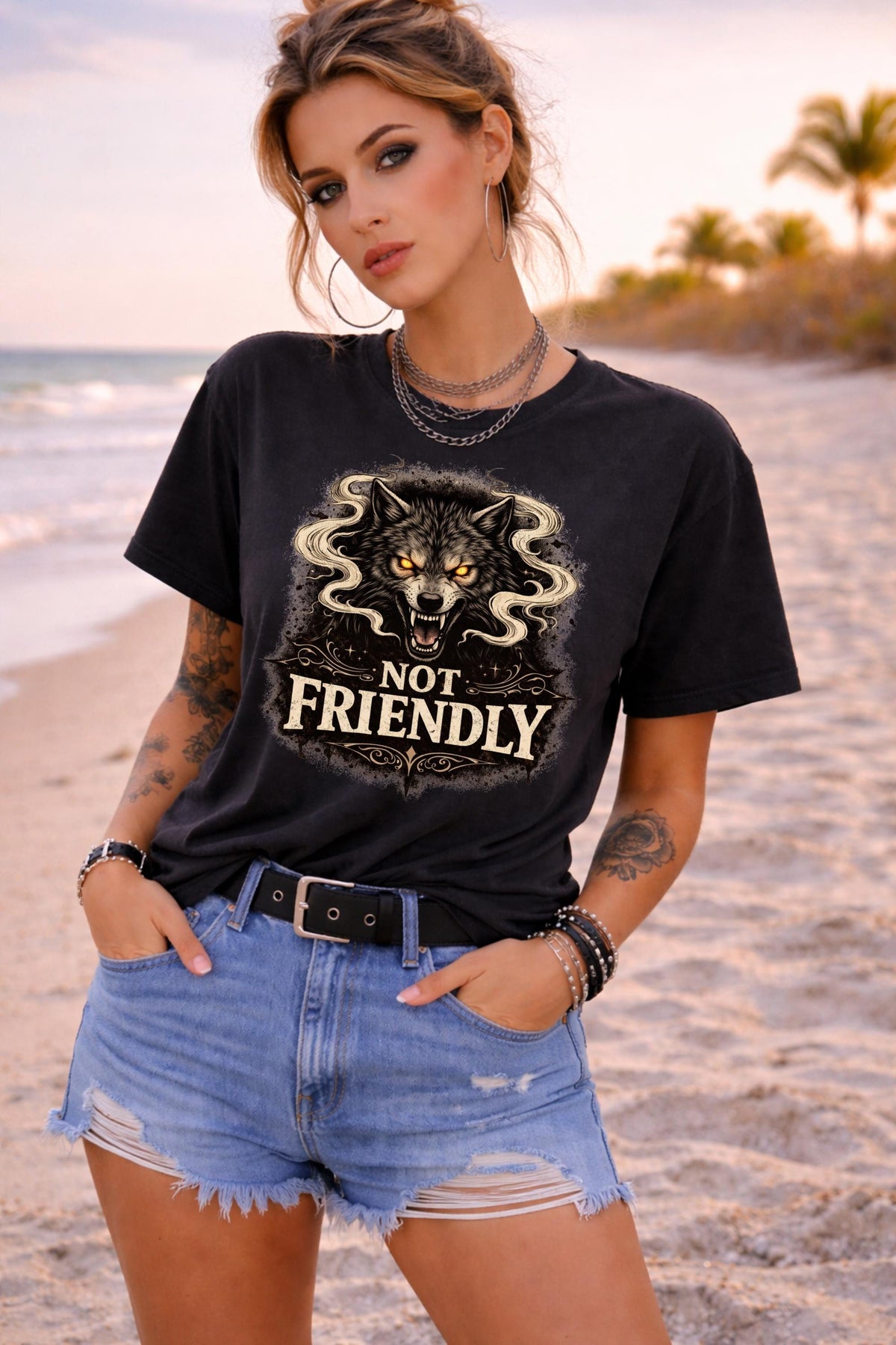 Graphic t-shirt featuring snarling wolf with glowing eyes and “Not Friendly” text, worn by model on beach with casual summer outfit