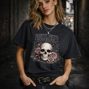 Graphic t-shirt featuring skull with roses and “Pretty Petty Powerful” text, styled on model with edgy streetwear aesthetic and dark neutral backdrop