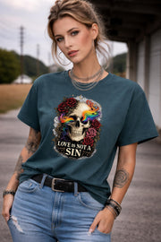 Graphic t-shirt featuring skull with rainbow accents and roses with “Love Is Not a Sin” text, styled on model with edgy alternative streetwear aesthetic