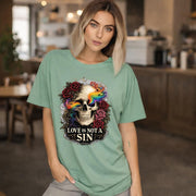 Graphic t-shirt featuring skull with rainbow accents and roses with “Love Is Not a Sin” text, styled on model with edgy alternative streetwear aesthetic