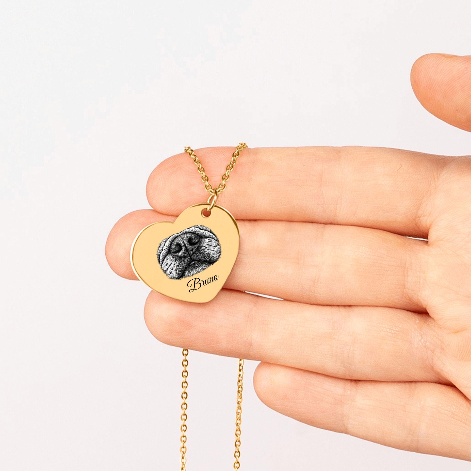 Close-up of engraved dog nose print on heart pendant necklace, detailed personalized pet keepsake