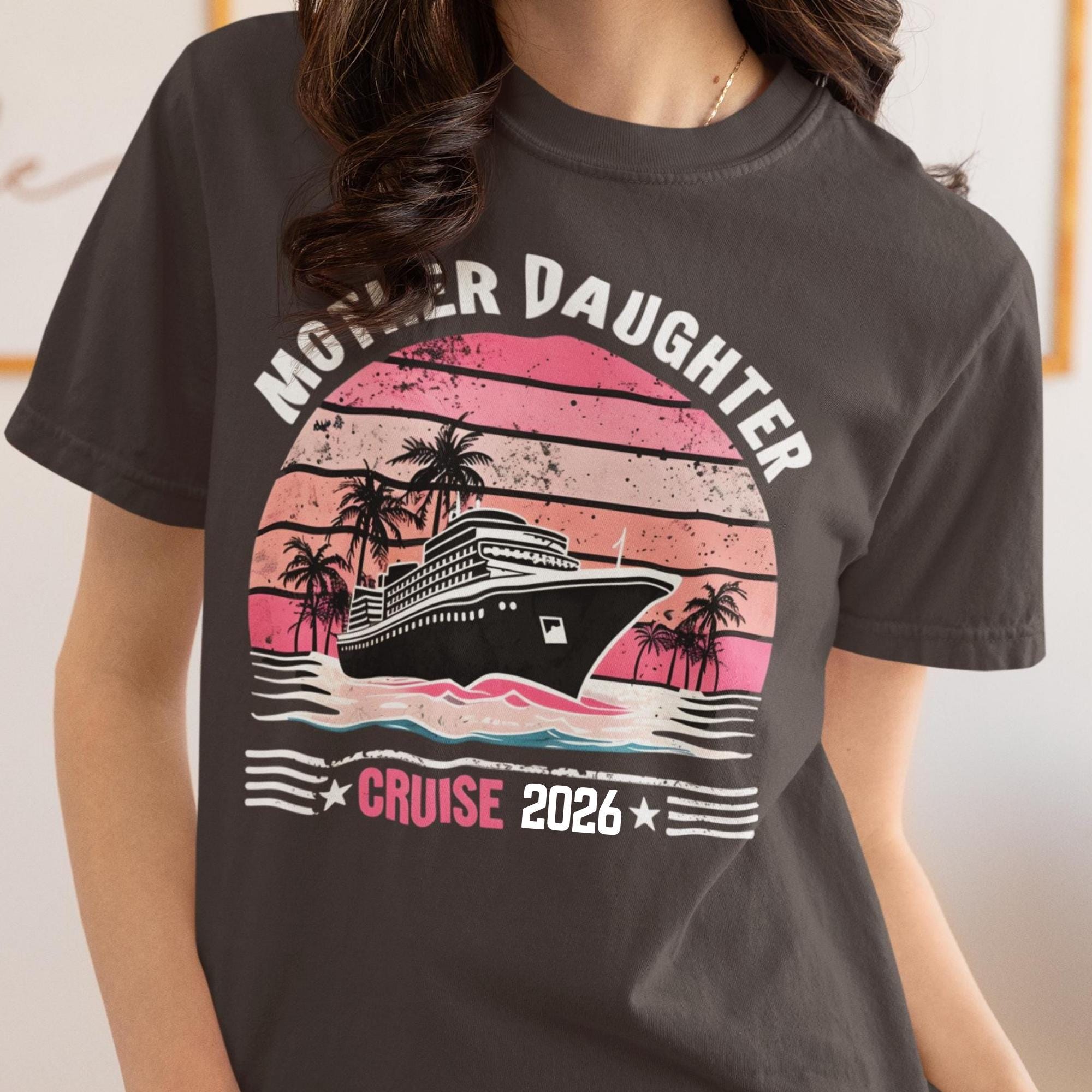 Woman wearing a  Comfort Colors t-shirt featuring a retro Mother Daughter Cruise 2026 design with a vintage sunset, palm trees, and cruise ship graphic