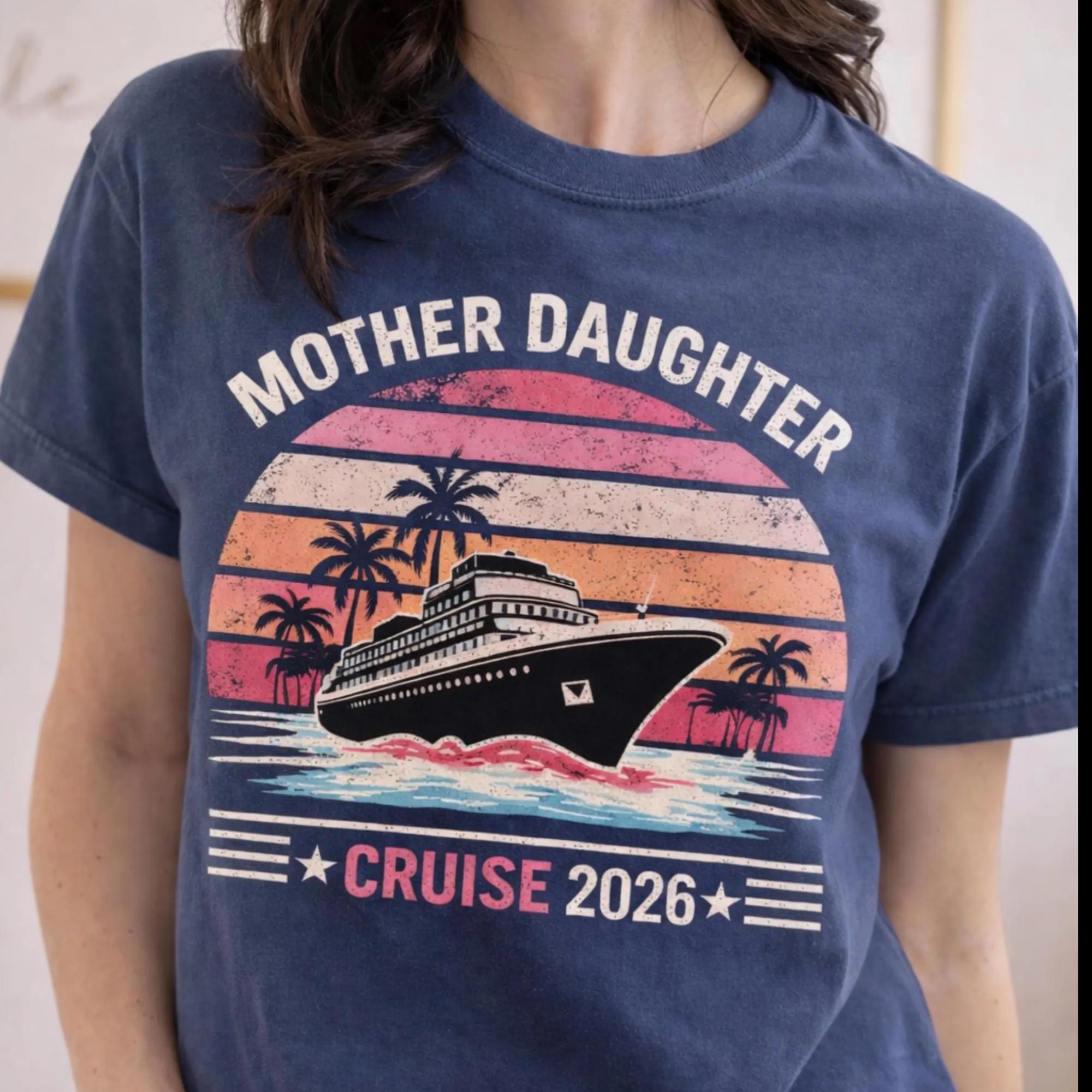 Woman wearing a blue jean Comfort Colors t-shirt featuring a retro Mother Daughter Cruise 2026 design with a vintage sunset, palm trees, and cruise ship graphic