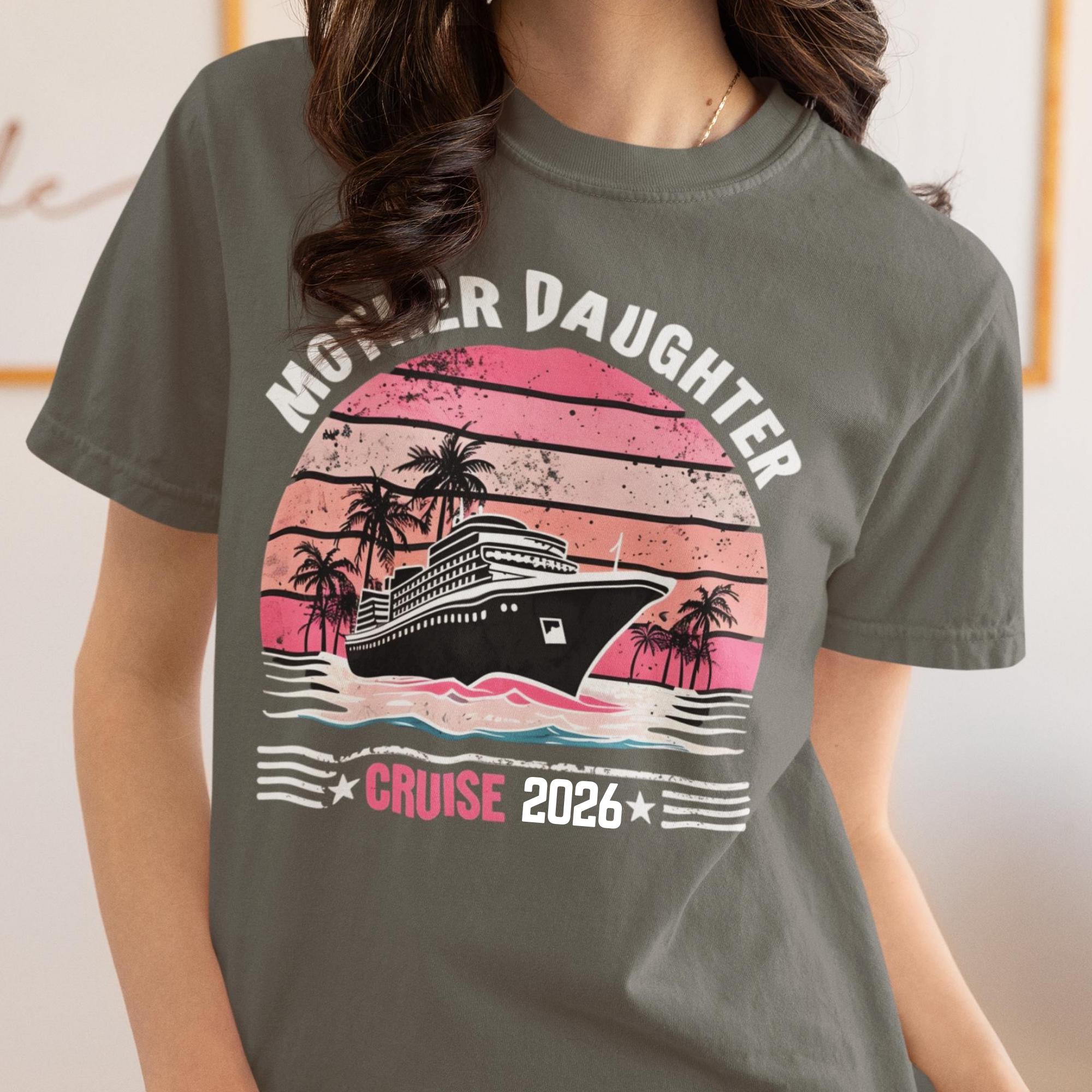 Woman wearing a Pepper Comfort Colors t-shirt featuring a retro Mother Daughter Cruise 2026 design with a vintage sunset, palm trees, and cruise ship graphic
