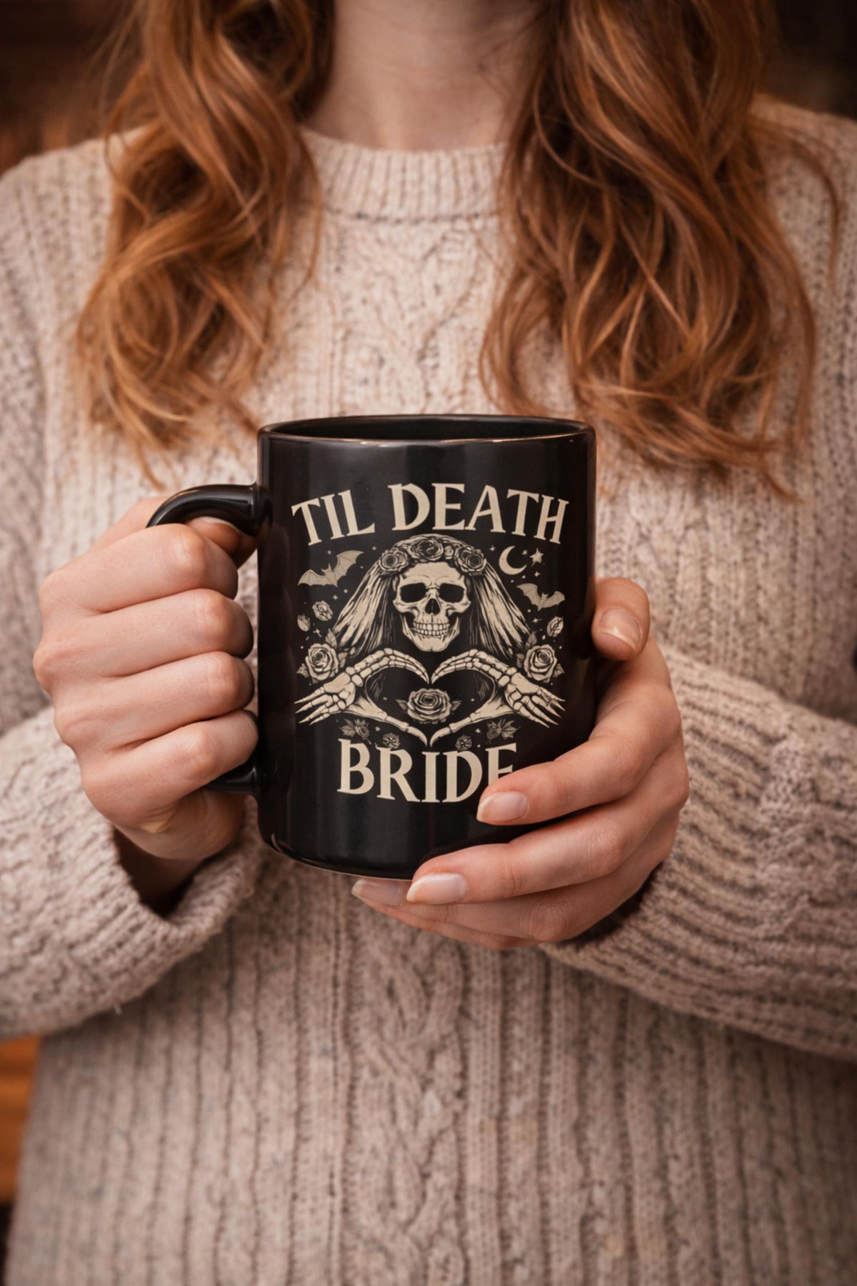 Black gothic coffee mugs featuring skeleton bride and groom artwork stacked together on wooden table with candlelight