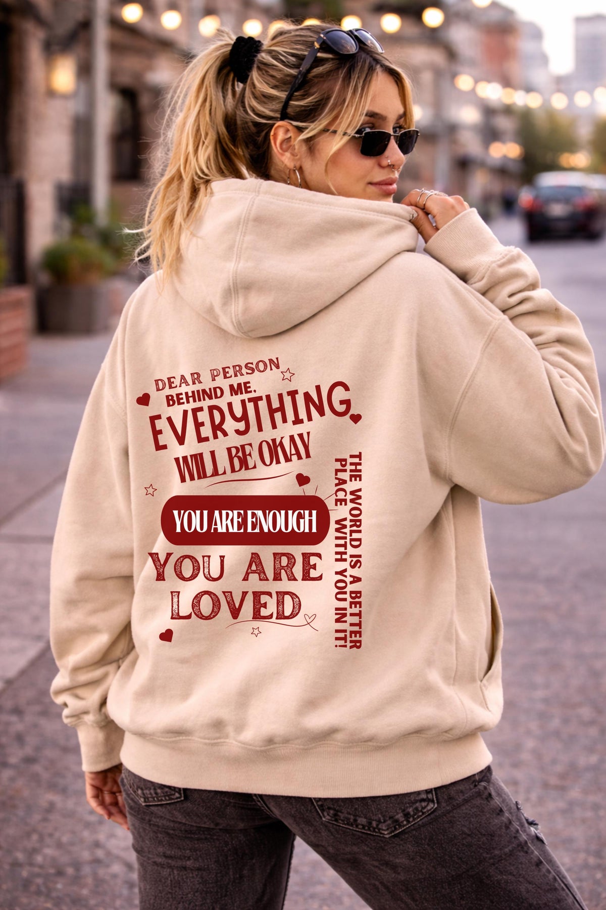 Woman wearing motivational hoodie featuring “you are enough” and “you are loved” message on the back