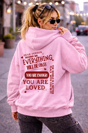 Woman wearing motivational hoodie featuring “you are enough” and “you are loved” message on the back