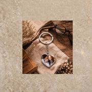 Silver heart keychain with romantic couple photo on cozy styled background