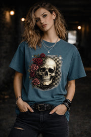 Comfort Colors 1717 t-shirt in blue spruce featuring a gothic skull with red roses and checkerboard background, worn by model outdoors