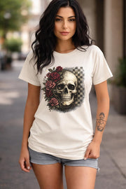 Comfort Colors 1717 t-shirt in ivory featuring a gothic skull with red roses and checkerboard background, worn by model outdoors