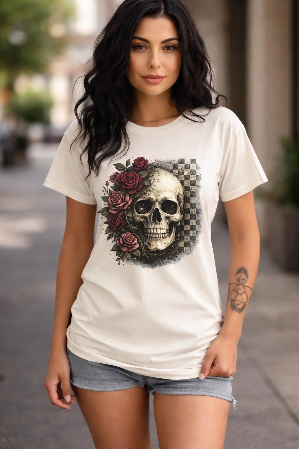 Comfort Colors 1717 t-shirt in ivory featuring a gothic skull with red roses and checkerboard background, worn by model outdoors