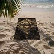 Black and gold lotus beach towel with mandala design laid on sandy beach near ocean with palm shadow