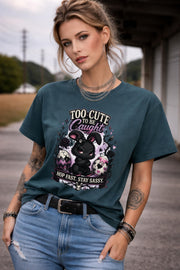 Woman wearing black graphic t-shirt with cute edgy bunny illustration and text Too Cute To Be Caught styled with denim jeans and accessories