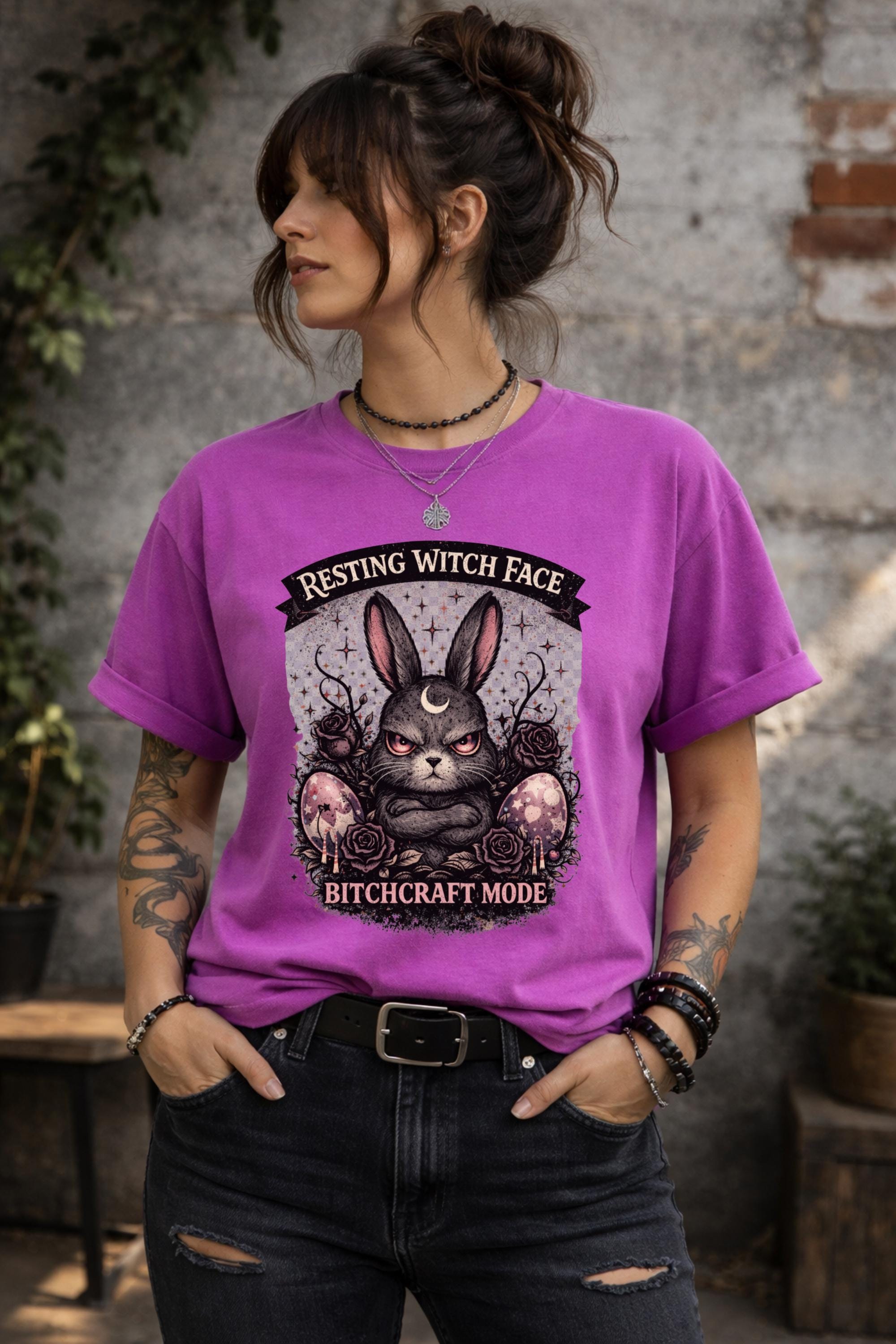 Woman wearing black gothic bunny graphic t-shirt with text Resting Witch Face Bitchcraft Mode styled with denim jeans and layered jewelry