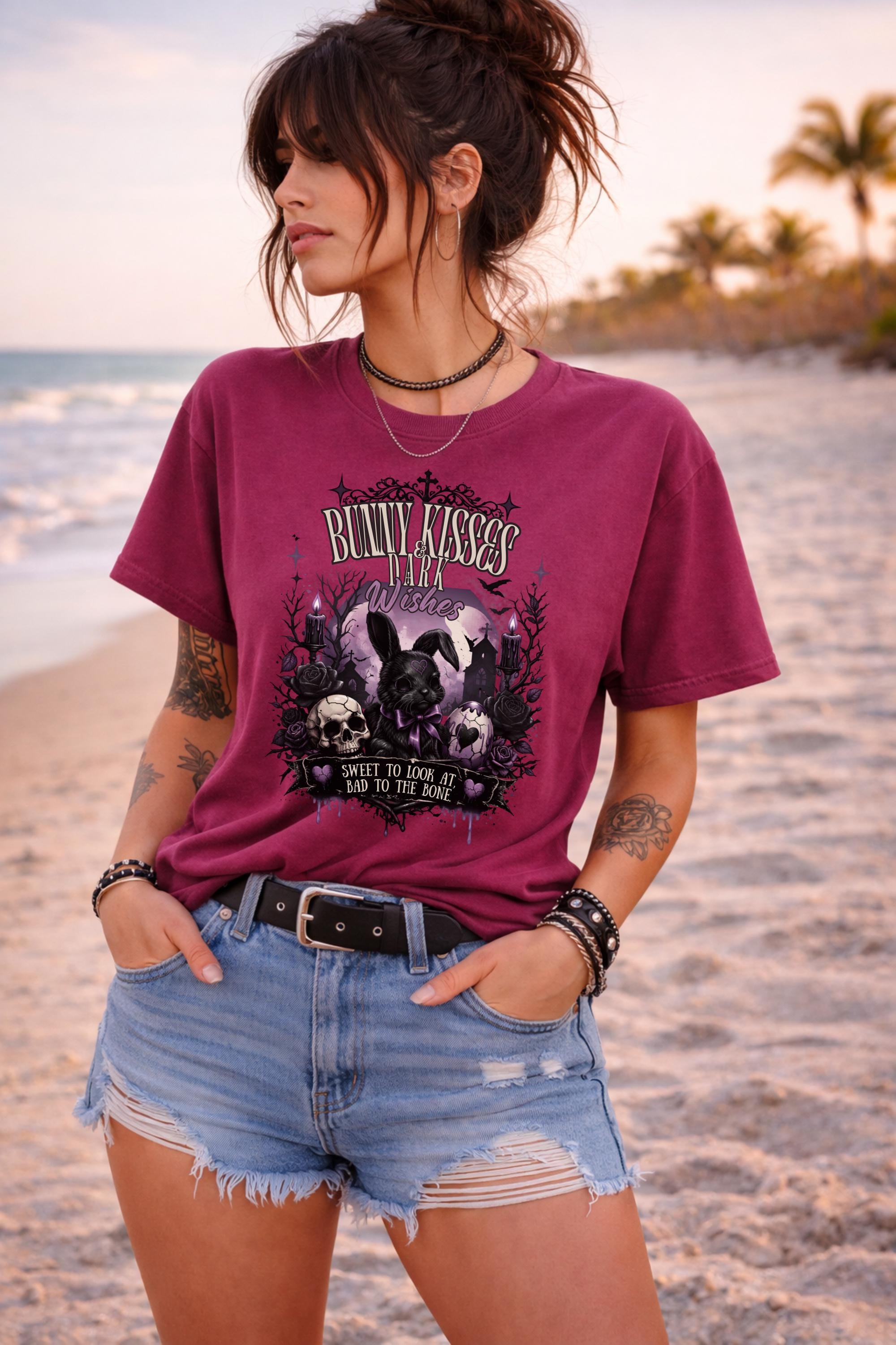 Woman wearing dark gothic bunny graphic t-shirt with text Bunny Kisses Dark Wishes Sweet To Look At Bad To The Bone styled with blue jean shorts