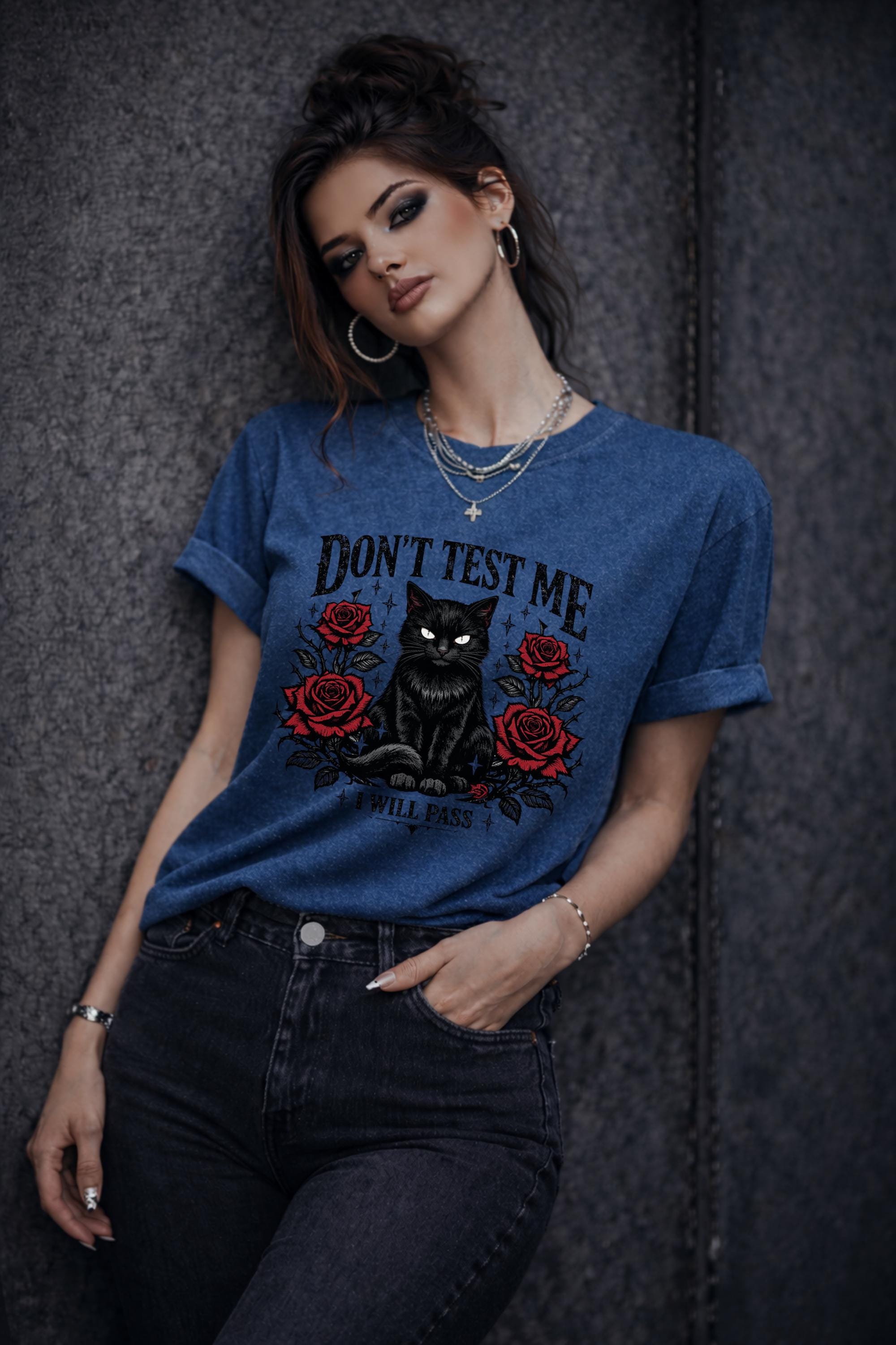 Graphic t-shirt featuring black cat with red roses and “Don’t Test Me I Will Pass” text, styled on model with edgy casual outfit in urban setting
