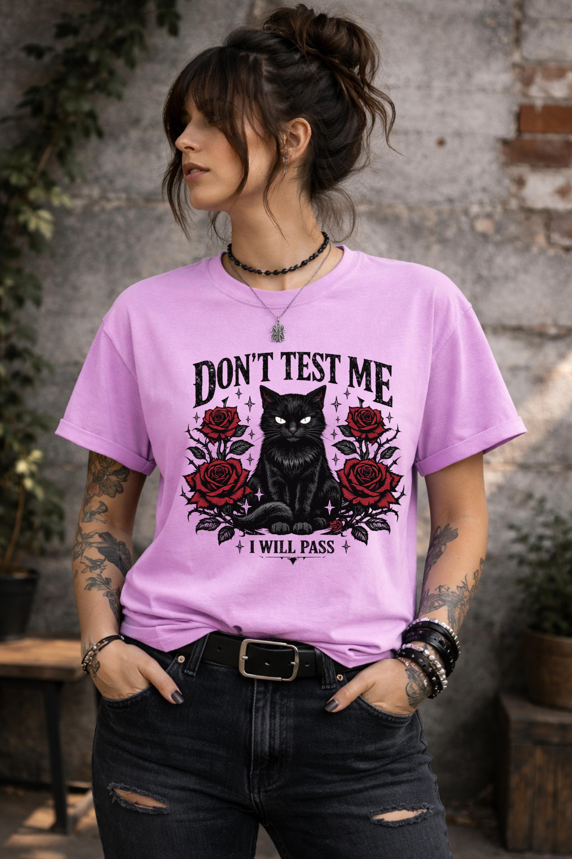 Graphic t-shirt featuring black cat with red roses and “Don’t Test Me I Will Pass” text, styled on model with edgy casual outfit in urban setting