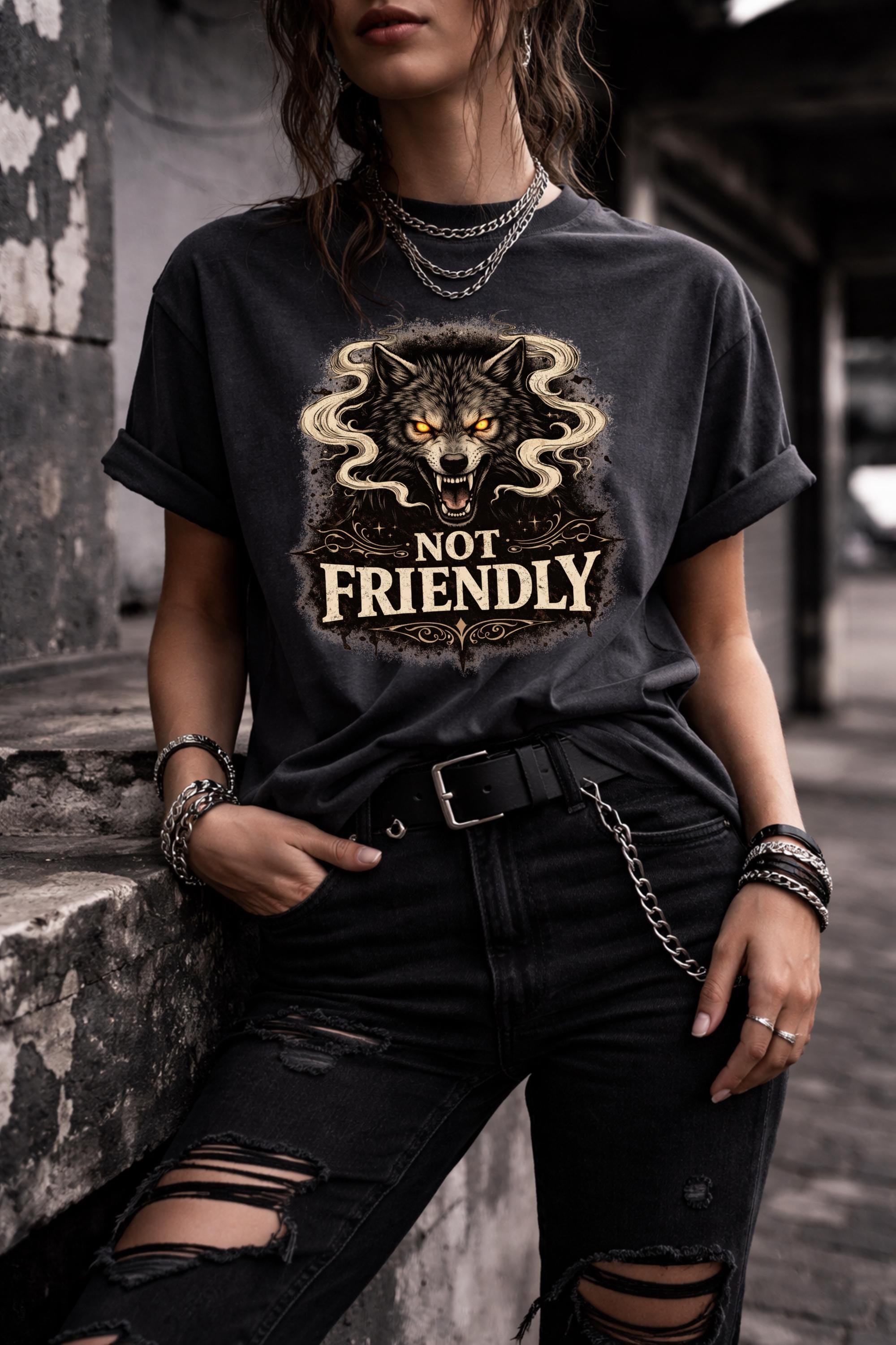 Graphic t-shirt featuring snarling wolf with glowing eyes and “Not Friendly” text, worn by model on beach with casual summer outfit
