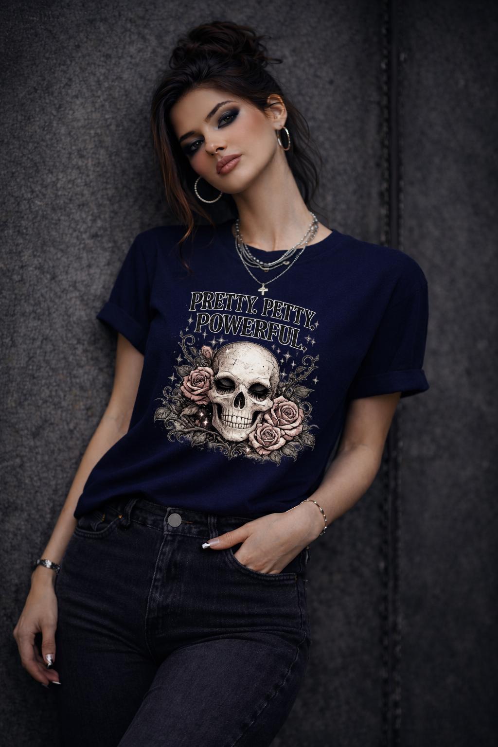 Graphic t-shirt featuring skull with roses and “Pretty Petty Powerful” text, styled on model with edgy streetwear aesthetic and dark neutral backdrop