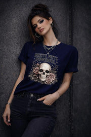 Graphic t-shirt featuring skull with roses and “Pretty Petty Powerful” text, styled on model with edgy streetwear aesthetic and dark neutral backdrop