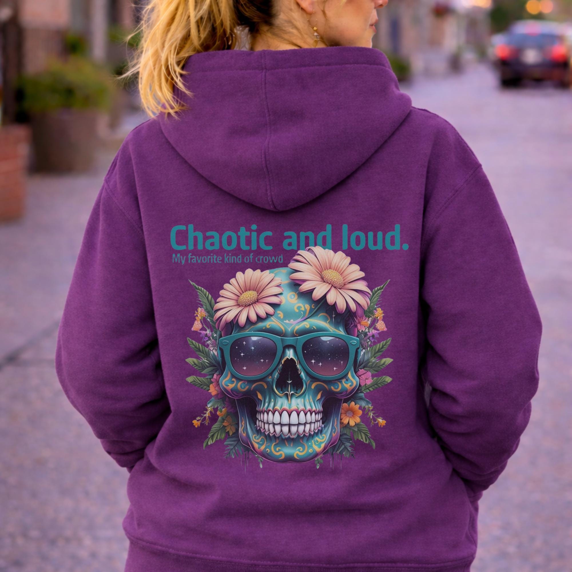 Back view of woman wearing a purple Premium Pullover Hoodie Cotton Heritage M2580 featuring a colorful floral skull with sunglasses design and the text “Chaotic and loud, my favorite kind of crowd” printed on the back