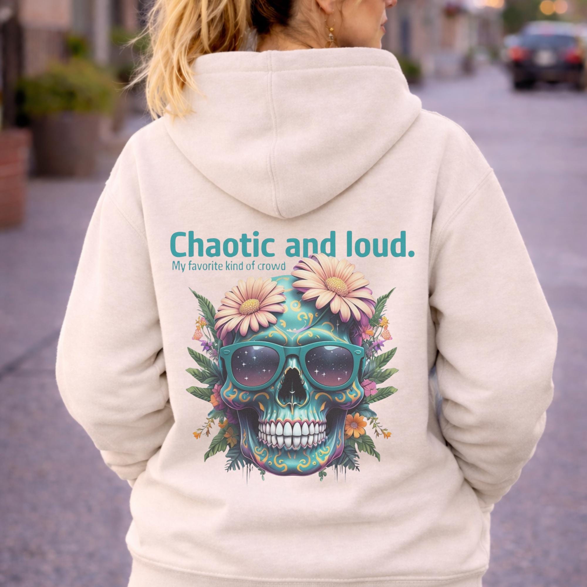 Back view of woman wearing a bone Premium Pullover Hoodie Cotton Heritage M2580 featuring a colorful floral skull with sunglasses design and the text “Chaotic and loud, my favorite kind of crowd” printed on the back