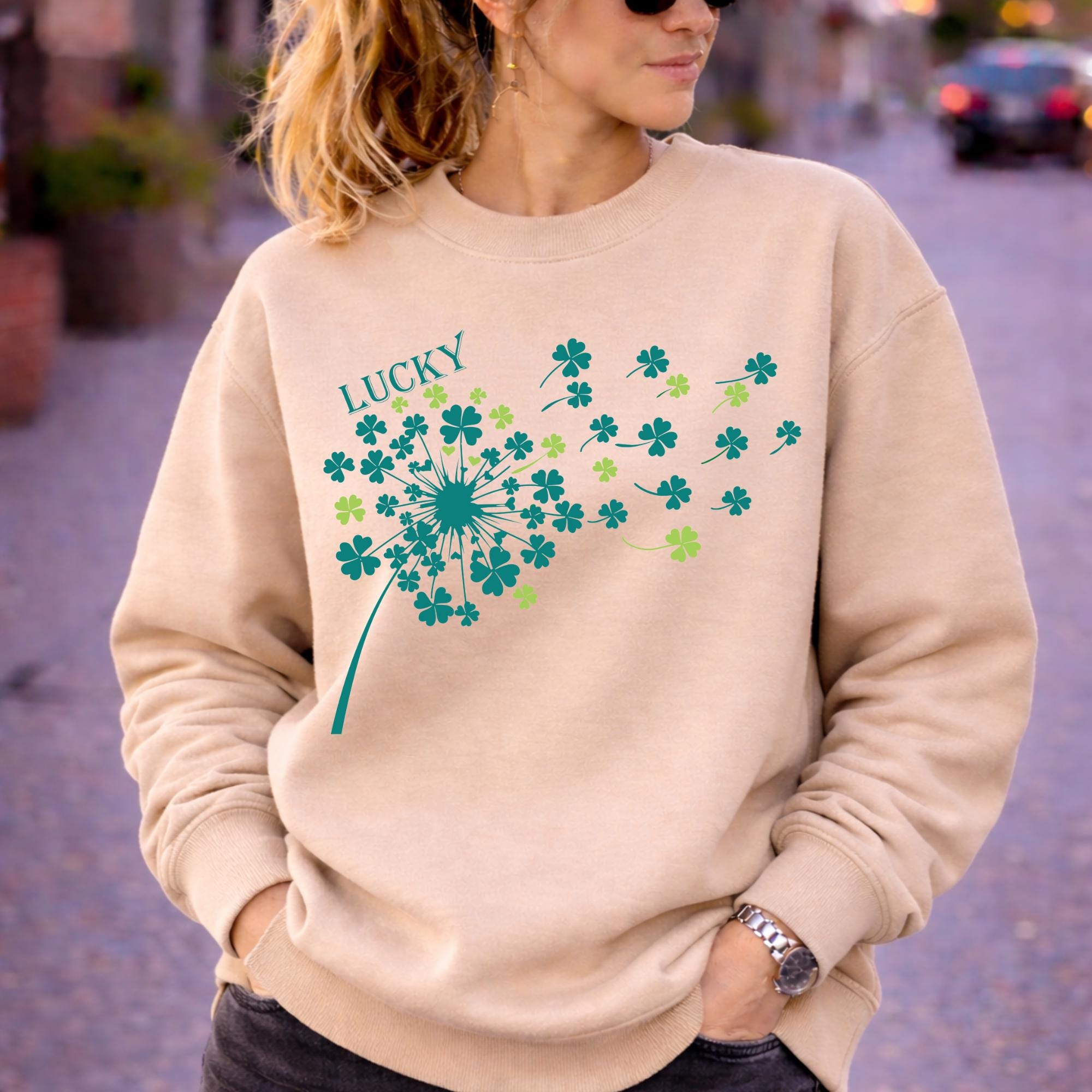 Woman wearing sand crewneck sweatshirt in casual outdoor setting with relaxed fit and soft fabric, styled with black jeans and sunglasses