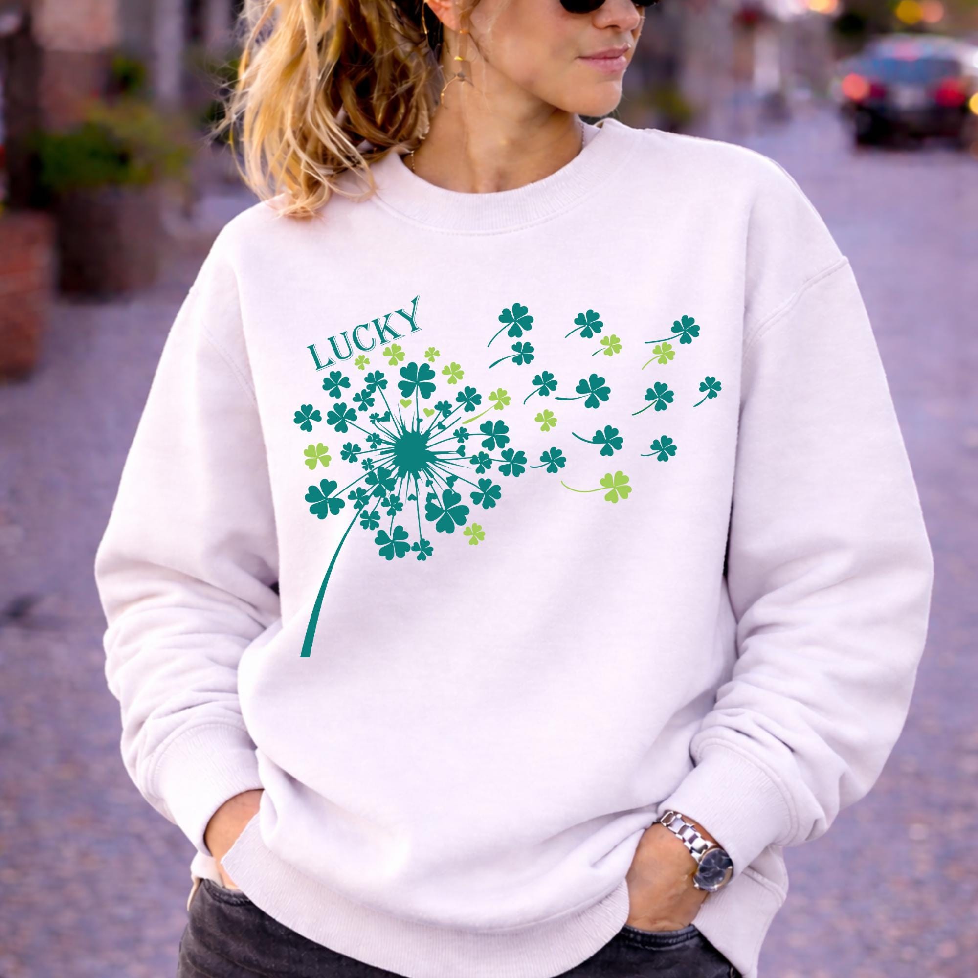 Woman wearing white crewneck sweatshirt in casual outdoor setting with relaxed fit and soft fabric, styled with black jeans and sunglasses