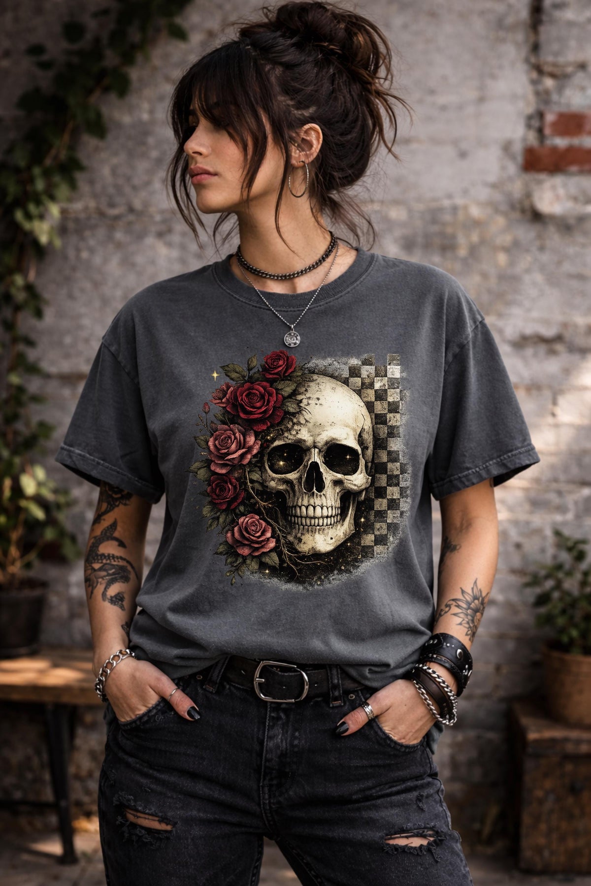 Comfort Colors 1717 t-shirt in pepper featuring a gothic skull with red roses and checkerboard background, worn by model outdoors