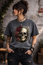 Comfort Colors 1717 t-shirt in pepper featuring a gothic skull with red roses and checkerboard background, worn by model outdoors