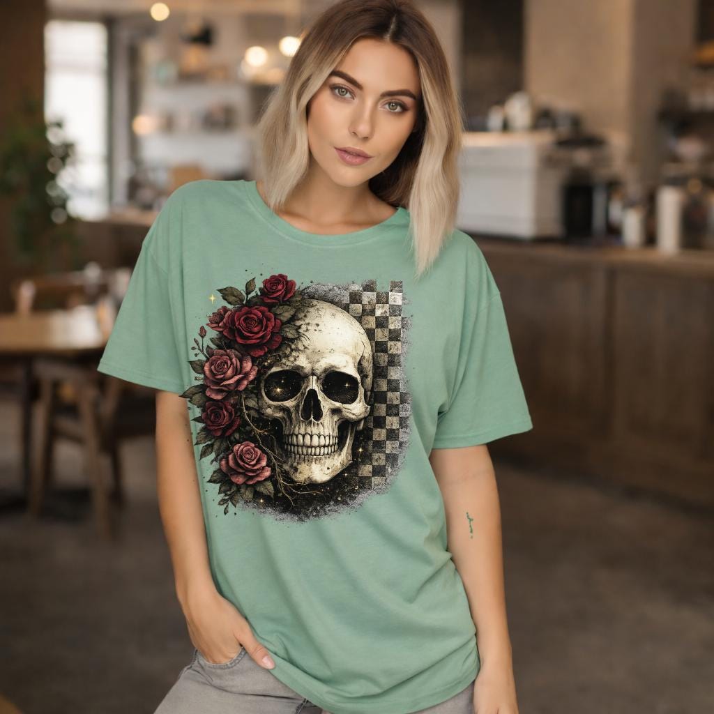 Comfort Colors 1717 t-shirt in bay featuring a gothic skull with red roses and checkerboard background, worn by model outdoors