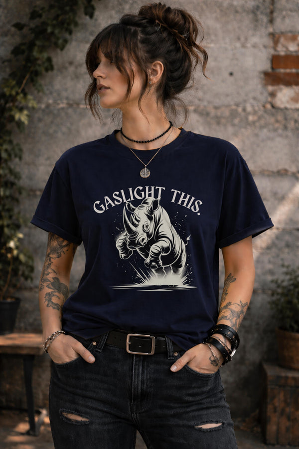 Woman wearing navy blue graphic t-shirt with gaslight this rhino design outdoors rustic background