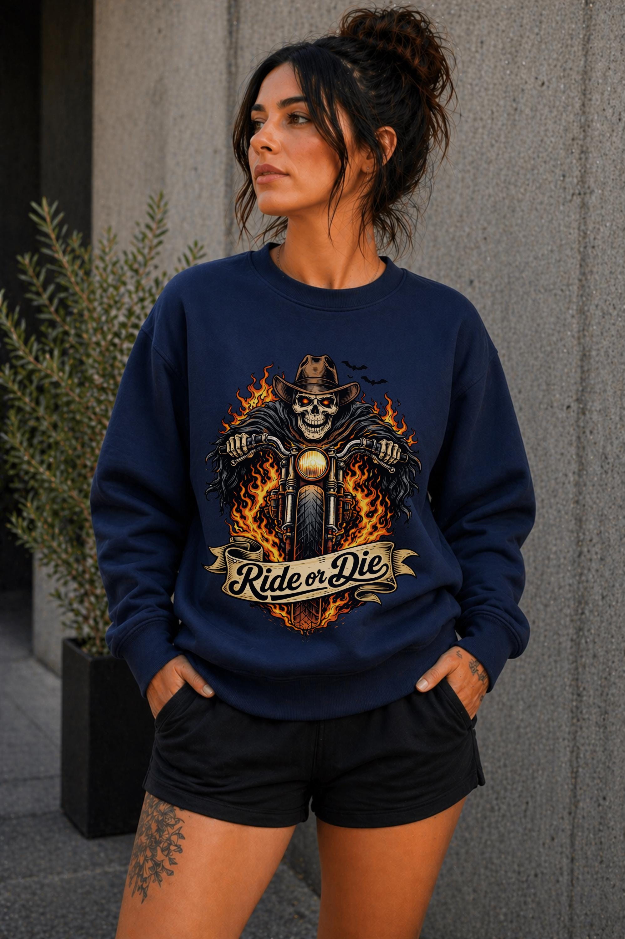 Woman wearing navy biker graphic shirt with skull motorcycle ride or die design