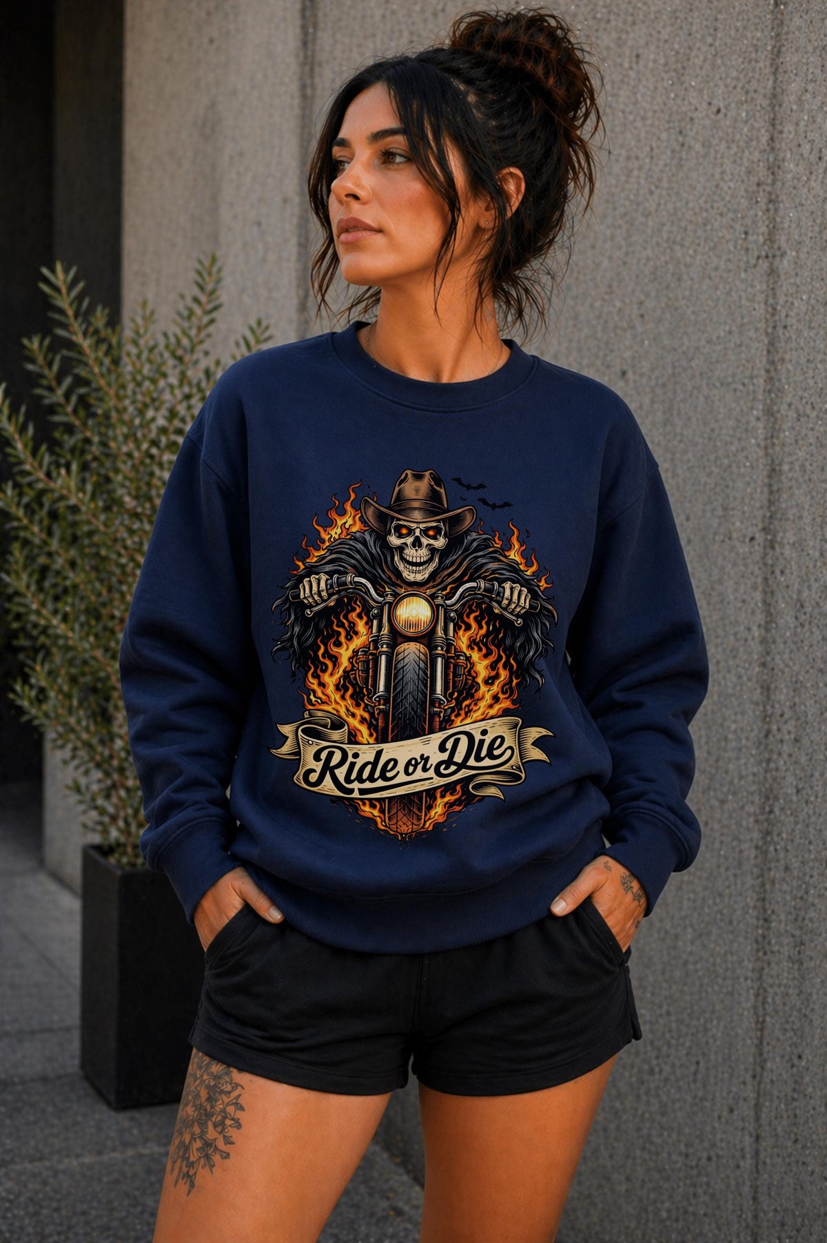 Woman wearing navy biker graphic shirt with skull motorcycle ride or die design