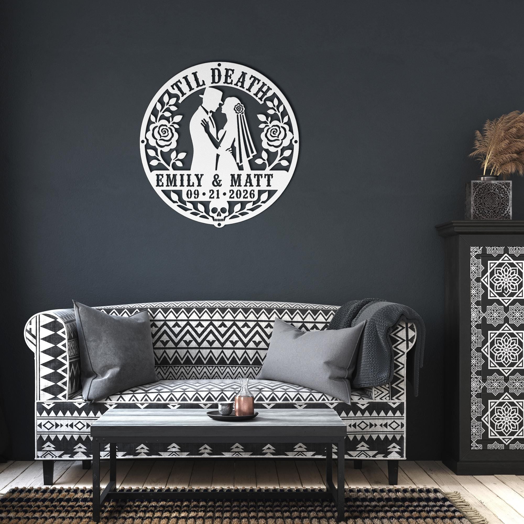 Gothic metal wall decor with til death couple design and custom names displayed above a rustic console with candles and skull accents
