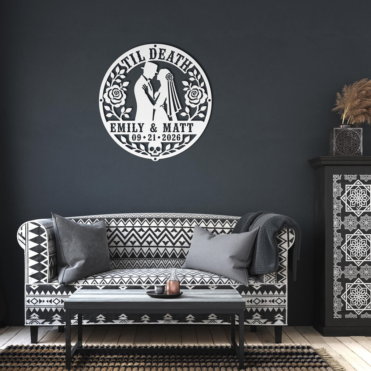Gothic metal wall decor with til death couple design and custom names displayed above a rustic console with candles and skull accents